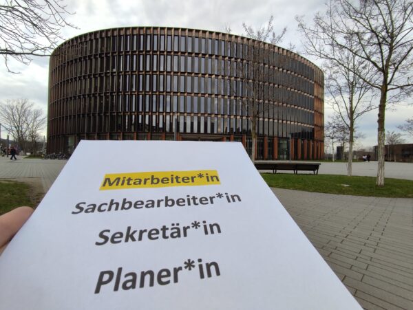 Ein ausgedrucktes Papier mit gegenderten Berufsbezeichnungen vor dem Freiburger Rathaus im Stühlinger