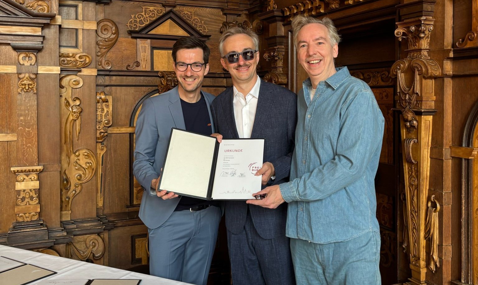 Wie gewünscht, ein großer Empfang: Jan Böhmermann und Olli Schulz besuchten OB Martin Horn am Sonntag im Rathaus - die Podcaster durften Urkunden unterzeichnen und sogar ein Band durchschneiden. Foto: Stadt Freiburg