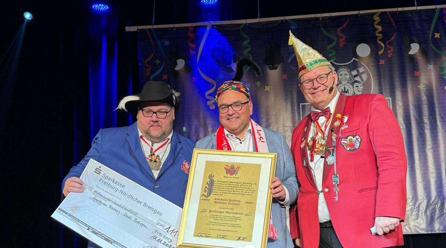 Sparkassen-Chef Daniel Zeiler (Mitte) durfte sich über den Narrenpreis der Breisgauer Narrenzunft freuen – hier mit Oberzunftmeister Matthias Moser (l.) und Elferratspräsident Achim Wiehle.